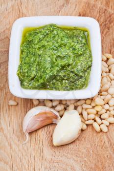 italian pesto sauce with pine nuts and garlic cloves on wooden board