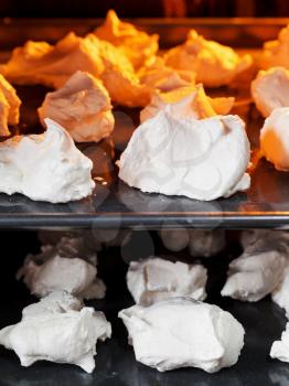 cooking of sweet dessert meringue on oven trays close up