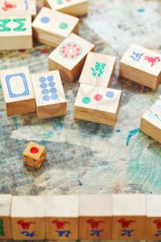 playing in mahjong game by wooden tiles on shabby table close up