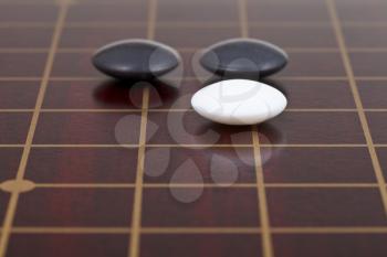 three stones during go game playing on goban close up