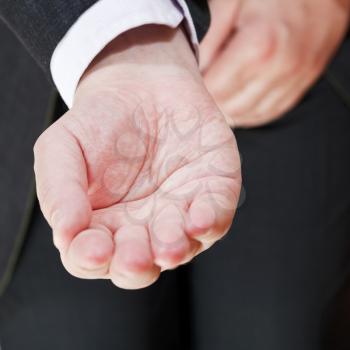 front view of businessman holding empty handful - hand gesture