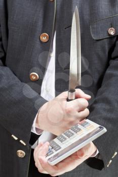 calculator and knife in businessman hands close up