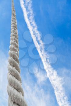 rope rises to blue sky with light white clouds
