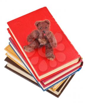 top view of soft toy bear sits on books isolated on white background
