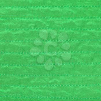 green color textile background from stitched silk fabric close up
