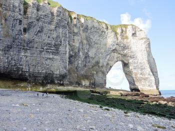 view of cliff with arch on english channel pebble beach of Etretat cote d'albatre, France