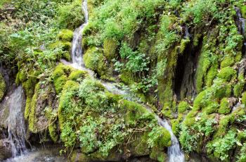 Nardis waterfall (detail) flows into lake from green mountain, Italy