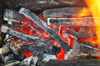 flame over hot wood-burning coals close up