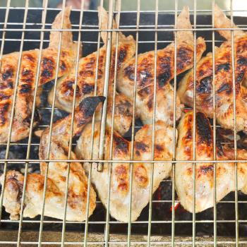 grilled chicken wings on brazier close up