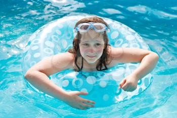 girl on swimming circle in blue open-air pool outdoors