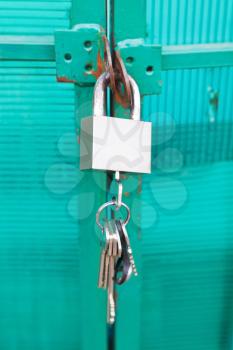 green door locked with padlock and bunch of keys