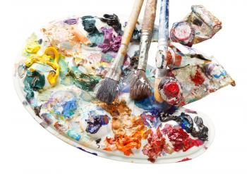 used artistic palette with oils, paint brushes and tubes isolated on white background