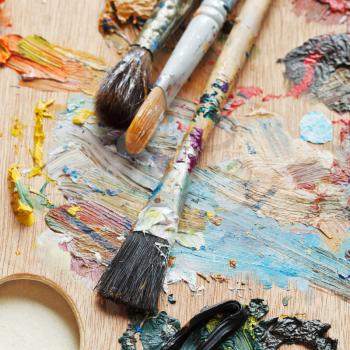 few paintbrushes on wood used oils artistic palette