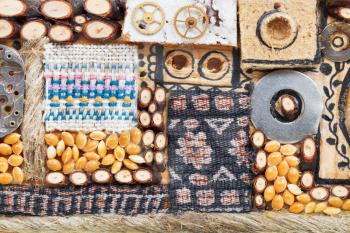 abstract ornament from natural and textile objects close up glued to wooden board