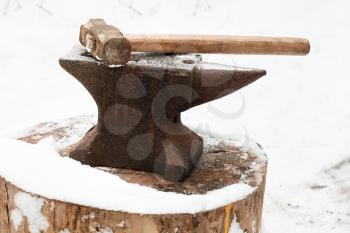 anvil with hammer in old abandoned village smithy in winter