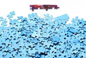 few connected pieces near of pile of jigsaw puzzles isolated on white background