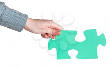 female hand holding big green paper puzzle piece isolated on white background