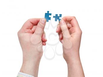 couple of male and female hands connecting little puzzle pieces isolated on white background