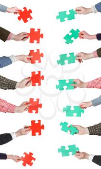 set of red and green puzzle pieces in opposite sides in people hands isolated on white background