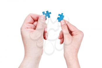 male and female hands holding little puzzle pieces isolated on white background