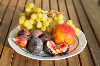 Crimean autumn seasonal fruit on plate on table outdoors