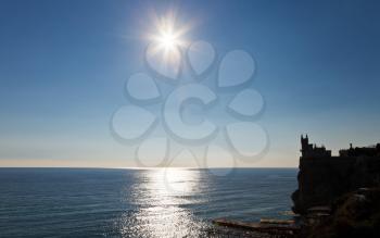 sun over Black Sea and Aurora cliff with Swallow's Nest castle on Southern Coast of Crimea