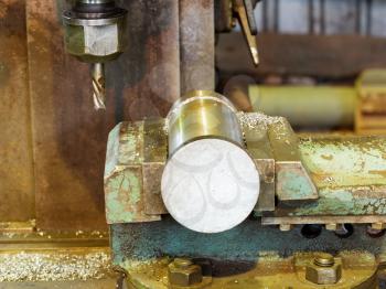 workpiece and drill of boring lathe machine close up in locksmith shop