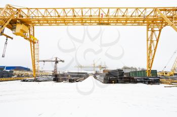 industrial scenery with bridge cranes and rolled metal products in warehouse