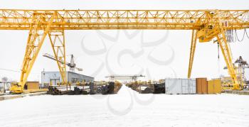 industrial view with bridge cranes and rolled metal products in warehouse