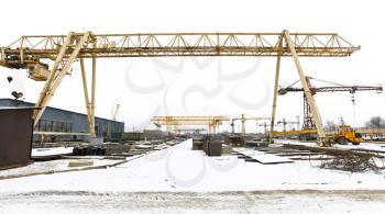 industrial landscape with bridge cranes and rolled metal products