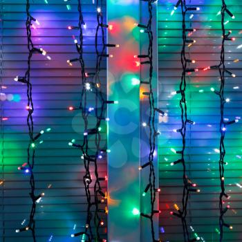 outdoor Christmas lamp strings decorate window in night