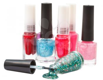 set of nail polish bottles and spilled green lacquer isolated on white