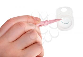 woman taking contact lens by forceps from the container isolated on white background