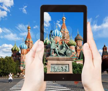 travel concept - tourist taking photo of Monument of Minin and Pozharsky on red Square in Moscow, Russia on mobile gadget