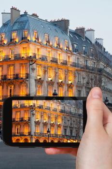 travel concept - tourist taking photo of boulevard Saint Michel in Paris on mobile gadget, France