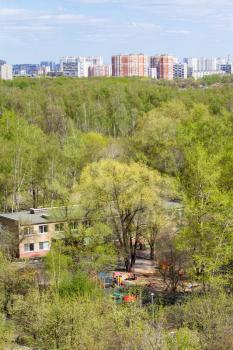 above view of kindergarten in green woods and city in sunny spring day