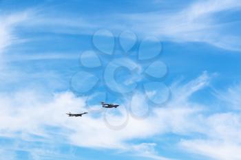 air refueling of strategic bomber aircraft in white clouds in blue sky