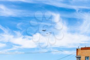 air refueling of battleplane aircraft in blue sky over urban house