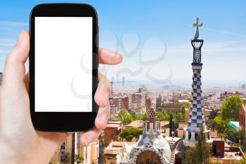 travel concept - tourist photograph skyline of Barcelona city, Spain on smartphone with cut out screen with blank place for advertising logo