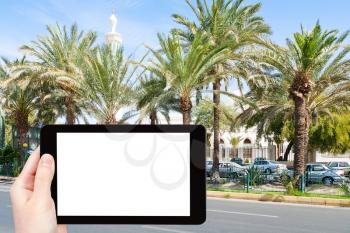 travel concept - tourist photograph Al-Sharif Al Hussein Bin Ali Mosque on King Hussein Street in Aqaba, Jordan on tablet pc with cut out screen with blank place for advertising logo