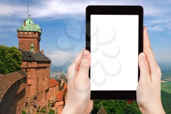travel concept - tourist photograph lands from chateau du Haut-Koenigsbourg, Alsace, France on tablet pc with cut out screen with blank place for advertising logo