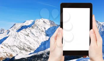 travel concept - tourist photograph MontBlanc mountain in Alps in Portes du Soleil region, Evasion - Mont Blanc, France on tablet pc with cut out screen with blank place for advertising logo