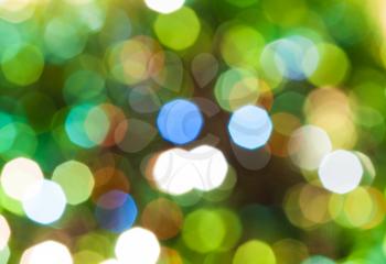 abstract blurred background - green shimmering Christmas lights of electric garlands on Xmas tree