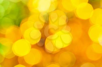 abstract blurred background - big yellow and green shimmering Christmas lights of electric garlands on Xmas tree