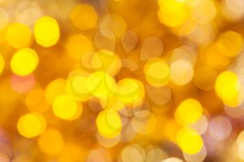 abstract blurred background - colorful yellow shimmering Christmas lights of electric garlands on Xmas tree
