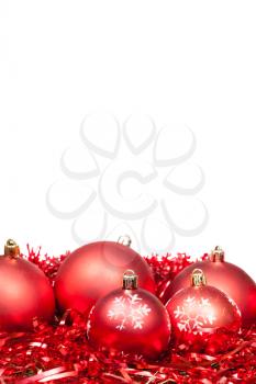 five red Xmas balls and tinsel isolated on white background