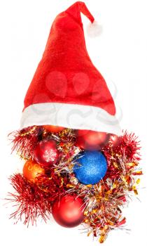 christmas gifts - xmas decorations and tinsel spill out from red santa hat on white background