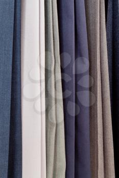 row of various woolen pants in tailoring atelier close up
