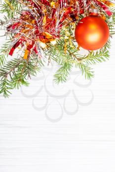 Christmas greeting card - border from one gold Xmas bauble and tree branch on blank paper background