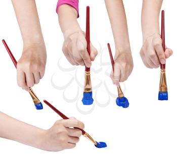 set of hands with flat art paintbrushes with blue painted tips isolated on white background